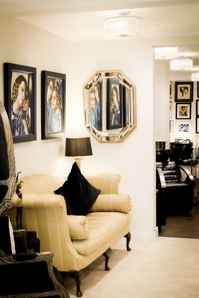 The Sloanes salon waiting area looks grand and luxurious with regency style seating and fine art paintings. 