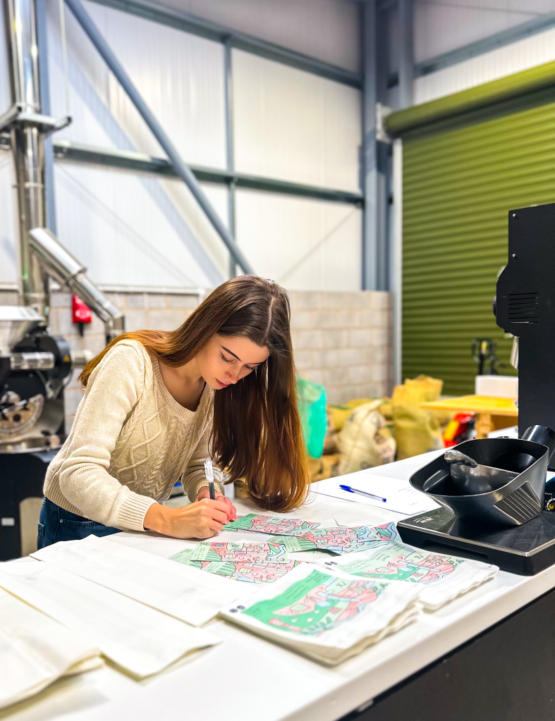 A Studio Coffee Roasters team member packaging freshly roasted coffee beans at the roastery. 